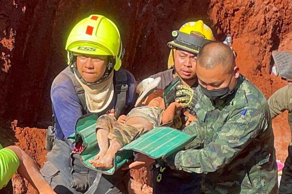 Following an overnight emergency operation, rescue workers and military carry a 1 year-old from a deep hole in the northern Thailand province of Tak, 420 kms. (260 miles) north of Bangkok, Tuesday, Feb. 7, 2023. The toddler, who is from Myanmar, fell into the 15 meter deep hole used for groundwater pipes yesterday evening.