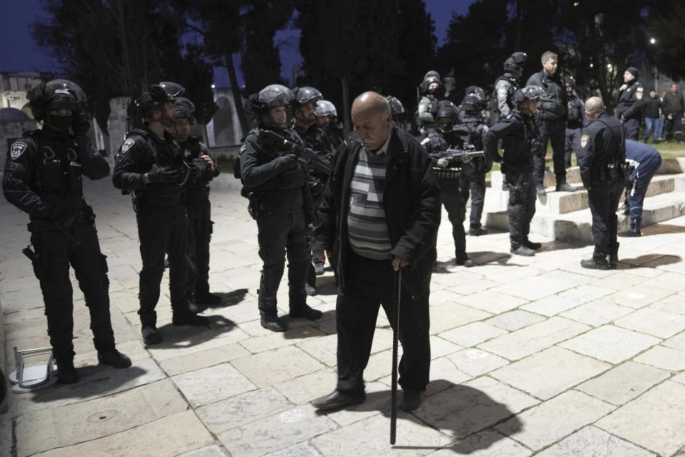 A Palestinian worshipper passes Israeli police at the Al-Aqsa Mosque compound following a raid of the site in the Old City of Jerusalem during the Muslim holy month of Ramadan, Wednesday, April 5, 2023. Palestinian media reported police attacked Palestinian worshippers, raising fears of wider tension as Islamic and Jewish holidays overlap.(AP Photo/Mahmoud Illean)