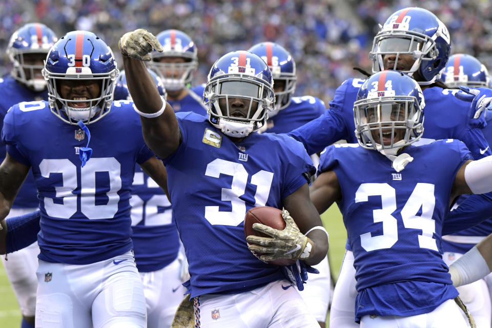 FILE - In this Nov. 18, 2018, file photo, New York Giants' Michael Thomas, center, celebrates an interception with his teammates during the first half of an NFL football game against the Tampa Bay Buccaneers in East Rutherford, N.J. Guaranteed payments for unrestricted free-agent contracts this month make up just over half of the total money to be paid, down a bit from 2018. “Obviously we are trying to figure how to improve that to 100 percent,” says Giants safety Michael Thomas, a member of the NFLPA’s executive committee. (AP Photo/Bill Kostroun, File)