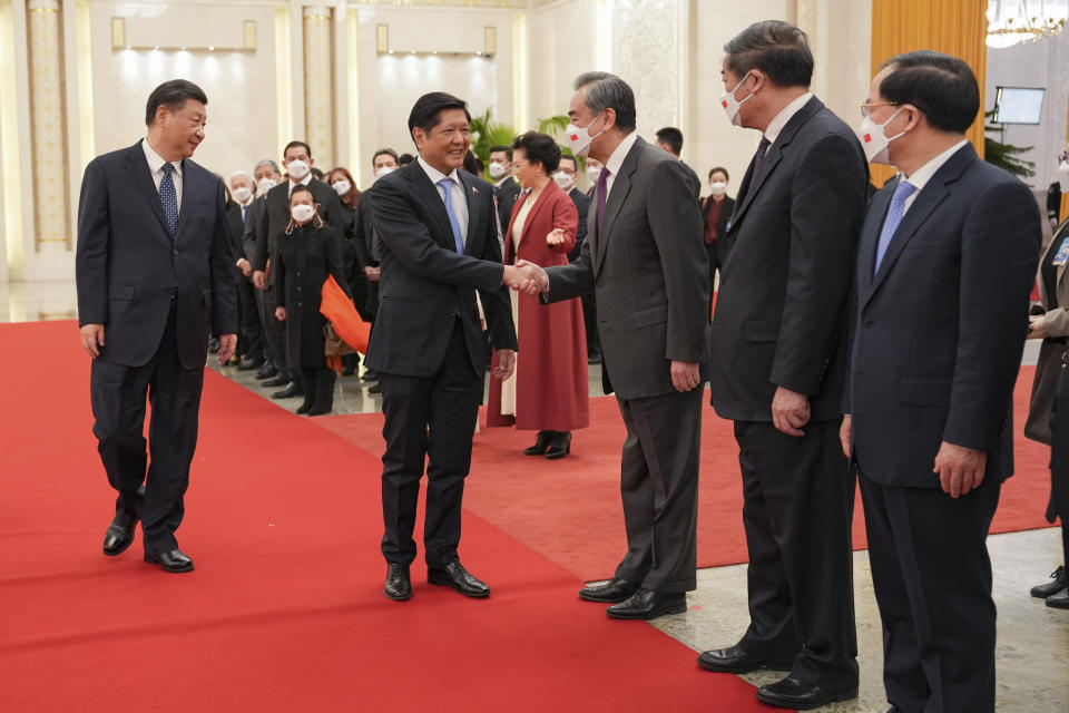 In this photo provided by the Philippines Office of the Press Secretary, Philippine President Ferdinand Marcos Jr., second from left, shakes hands with Chinese Foreign Minister Wang Yi while President Xi Jinping, left, looks on during a welcome ceremony at the Great Hall of the People in Beijing, Wednesday, Jan. 4, 2023. Marcos is pushing for closer economic ties on a visit to China that seeks to sidestep territorial disputes in the South China Sea. (Philippines Office of the Press Secretary via AP)