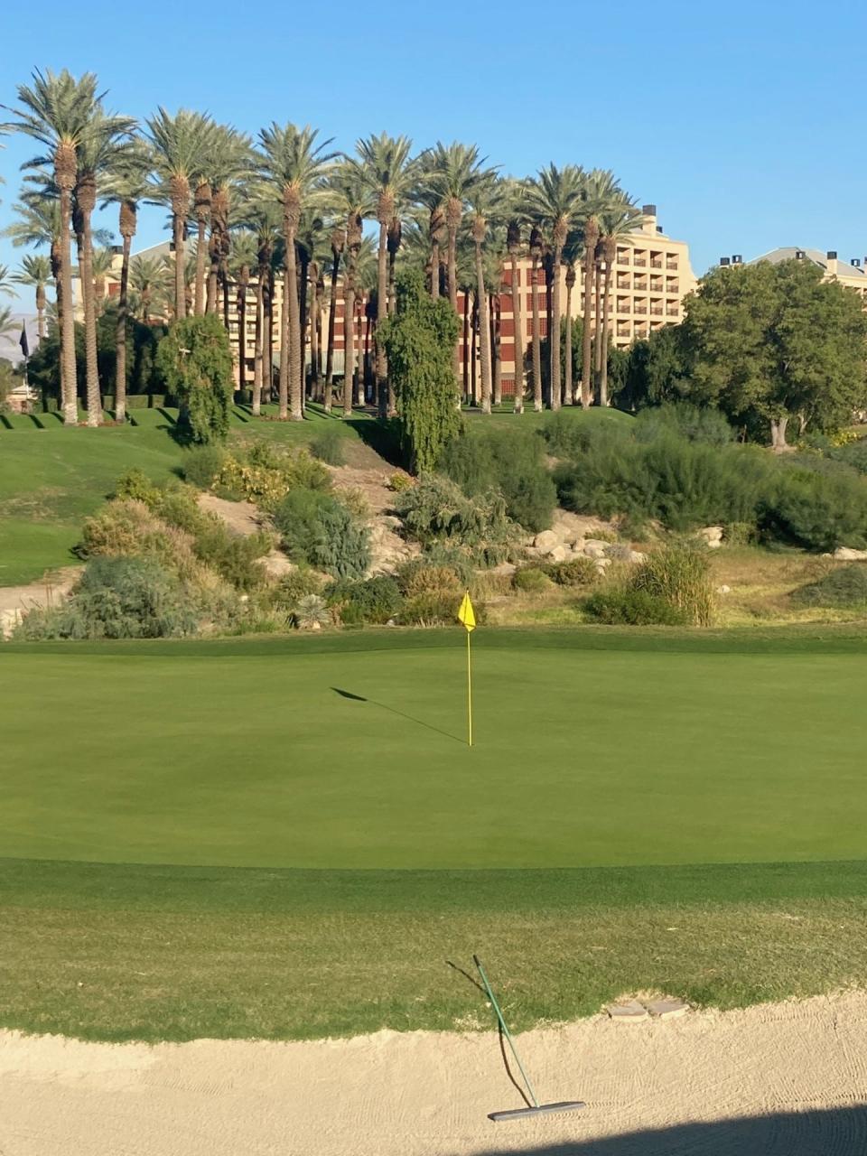 The 18th green of the Players Course at Indian Wells Golf Resort, with the Renaissance Esmeralda hotel in the background