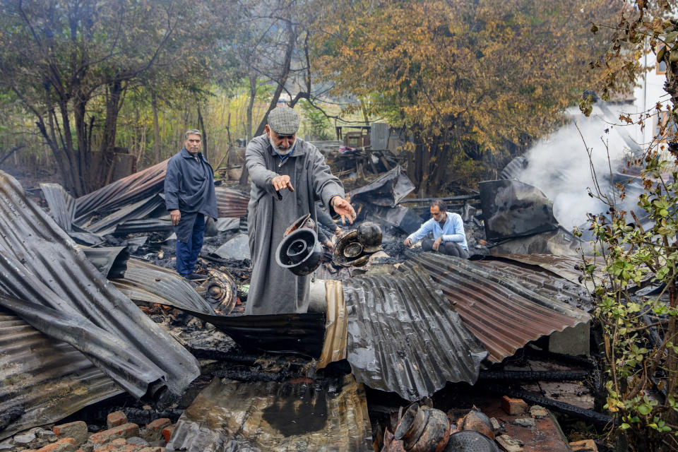 Kashmiris salvage items after a fire gutted several houseboats early morning in the interiors of Dal Lake, on the outskirts of Srinagar, Indian controlled Kashmir, Saturday, Nov. 11, 2023. A massive fire engulfed some wooden houseboats on Saturday and three charred bodies were recovered from the wreckage, officials said. (AP Photo/Dar Yasin)