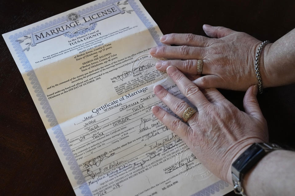 Mary Bishop-Baldwin and Sharon Bishop-Baldwin pose for a photo with their marriage license in their home Tuesday, Nov. 29, 2022, in Broken Arrow, Okla. (AP Photo/Sue Ogrocki)