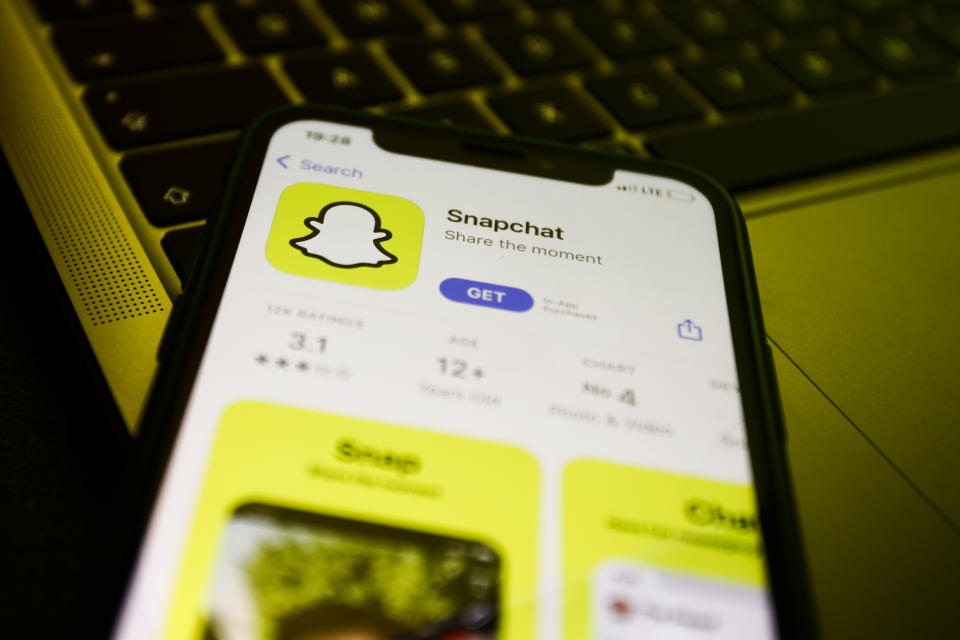 Snapchat on the App Store displayed on a phone screen and a laptop keyboard are seen in this illustration photo taken in Krakow, Poland on August 10, 2022. (Photo by Jakub Porzycki/NurPhoto via Getty Images)