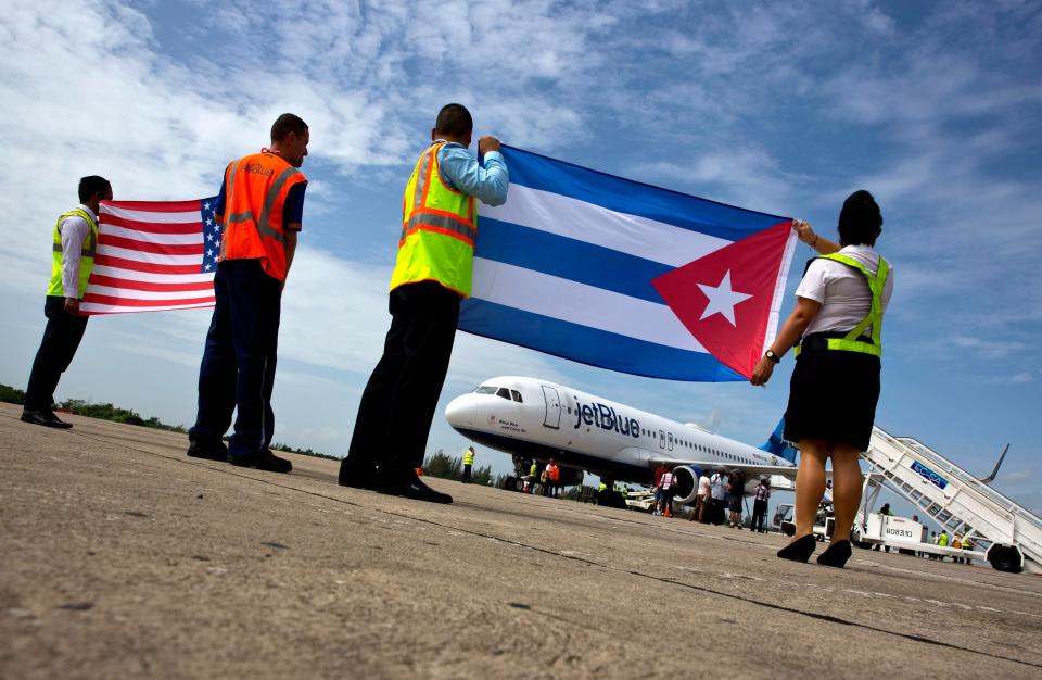 Airport workers receive JetBlue flight 387, the first commercial flight between the U.S. and Cuba in more than a half-century, holding the United States, and the Cuban national flag, on the airport tarmac on Aug. 31, 2016, in Santa Clara, Cuba.