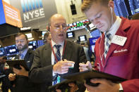 Gordon Charlop, center, and Christian Bader work at the New York Stock Exchange, Monday, Sept. 16, 2019. Global stock markets sank Monday after crude prices surged following an attack on Saudi Arabia's biggest oil processing facility. (AP Photo/Mark Lennihan)