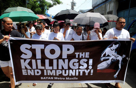 FILE PHOTO: Relatives and loved ones of Leover Miranda, 39, a drug-related killings victim, hold a streamer calling to stop the continuing rise of killings due to the President Rodrigo Duterte's ruthless war on drugs, during a funeral march at the north cemetery in metro Manila, Philippines August 20, 2017. REUTERS/Romeo Ranoco