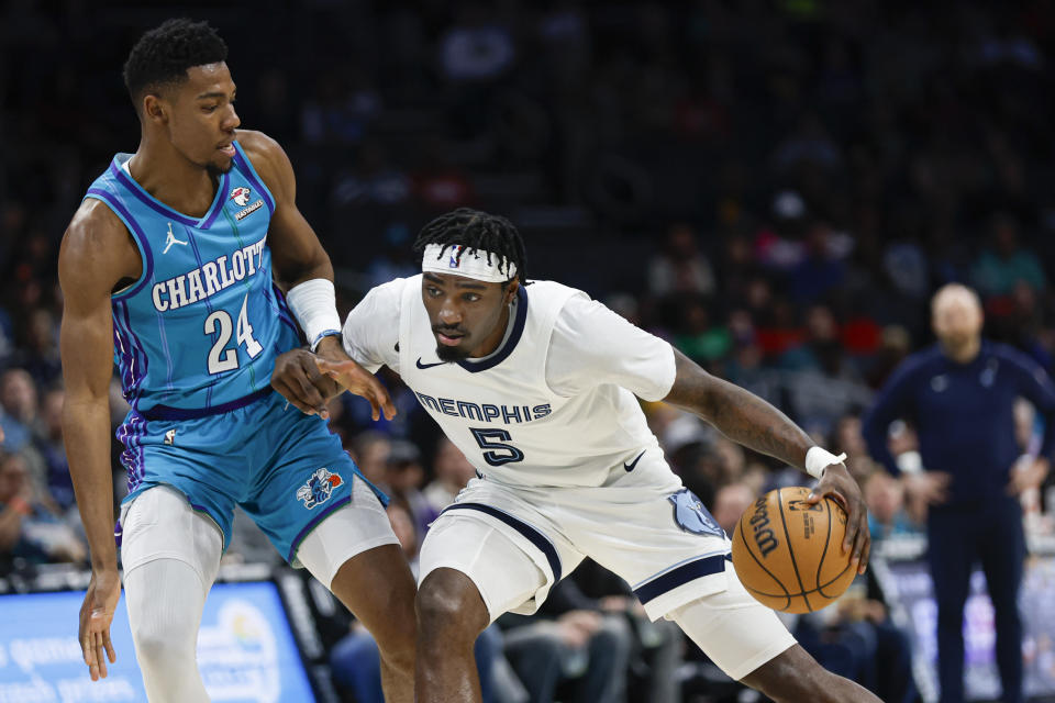 Memphis Grizzlies guard Vince Williams Jr., right, drives into Charlotte Hornets forward Brandon Miller during the first half of an NBA basketball game in Charlotte, N.C., Saturday, Feb. 10, 2024. (AP Photo/Nell Redmond)