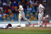 West Indies cricketer Carlton Baugh (L) gets run out as Australian bowler Nathan Lyon celebrates during the second day of the first-of-three Test matches between Australia and West Indies at the Kensington Oval stadium in Bridgetown on April 8, 2012. AFP PHOTO/Jewel Samad (Photo credit should read JEWEL SAMAD/AFP/Getty Images)