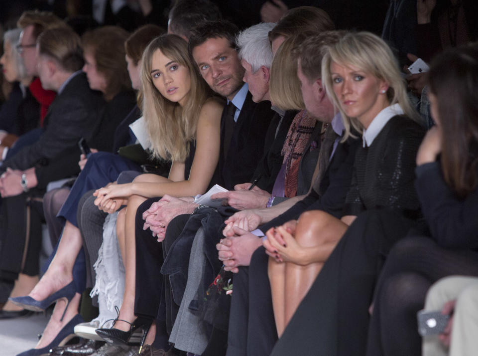 British model Suki Waterhouse, centre left, and her boyfriend U.S actor Bradley Cooper, centre right, watch the show by Tom Ford during London Fashion Week Autumn/Winter 2014, at Lindley Hall in central London, Monday, Feb. 17, 2014. (Photo by Joel Ryan/Invision/AP)