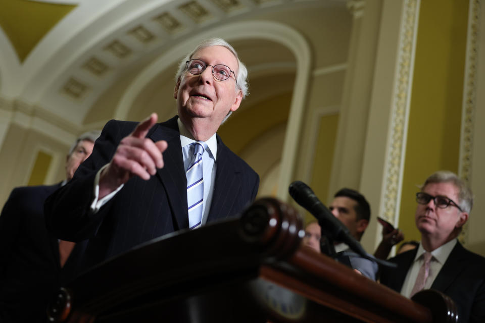 Senate Minority Leader Mitch McConnell speaks to reporters from a podium.