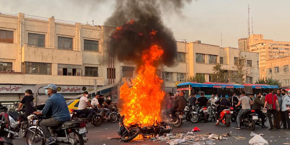 A large fire burns in the middle of a street in Tehran.