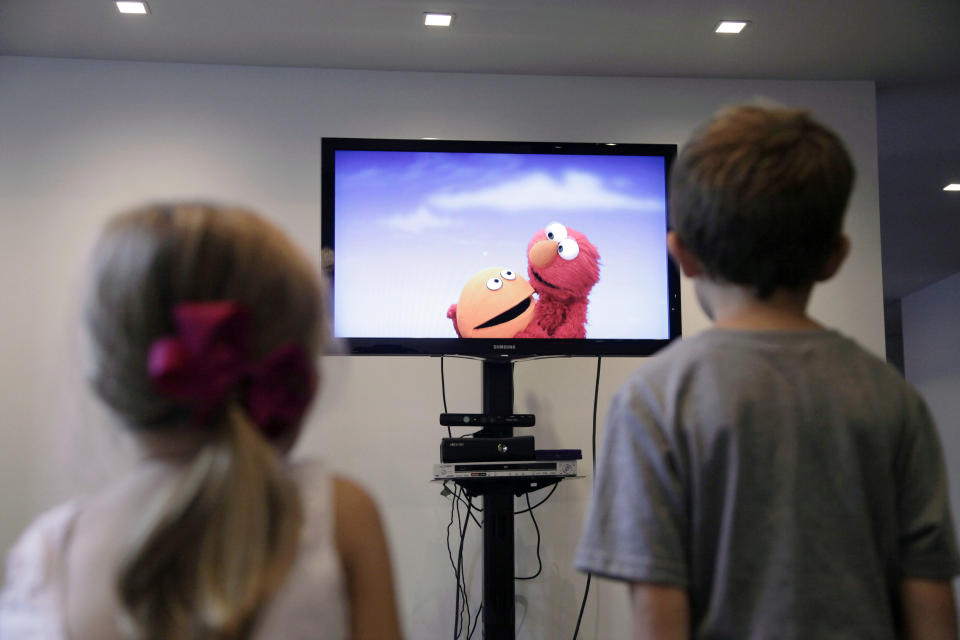 In this Sept. 5, 2012, photo, from left, Zoe Shyba, 3, and Aidan Lain, 7, play "Kinect Sesame Street TV" at the Sesame Street Workshop in New York. "Kinect Sesame Street TV", launching Tuesday, Sept. 18, 2012, uses Kinect, a motion and voice-sensing controller created by Microsoft, to give Elmo, Big Bird and the rest of the Sesame Street crew a chance to have a real two-way conversation with their pint-sized audience. The effort represents the next step in the evolution of television, adding an interactive element to what's still largely a passive, lean-back experience. (AP Photo/Mark Lennihan)