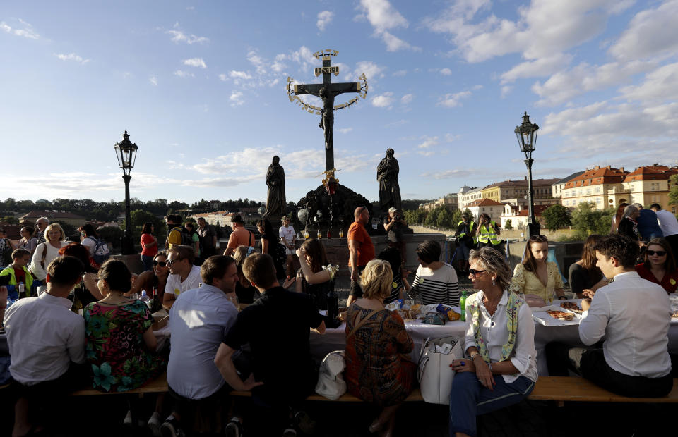 Residents sit to dine on a 500 meter long table set on the medieval Charles Bridge, after restrictions were eased following the coronavirus pandemic in Prague, Czech Republic, Tuesday, June 30, 2020.<span class="copyright">Petr David Josek —AP Photo/Getty Images</span>