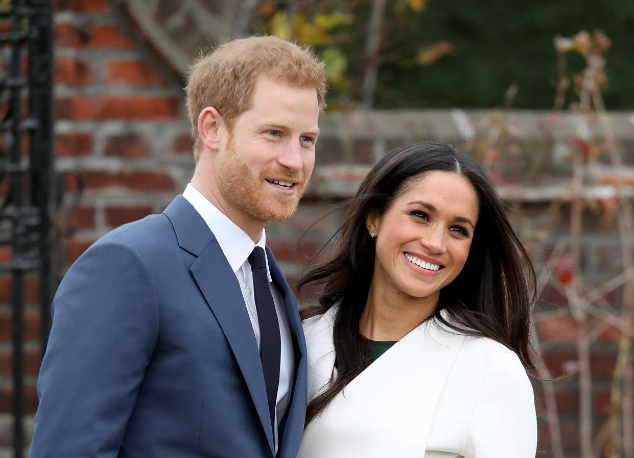 Prince Harry and Meghan Markle stand close together during a photoshoot.