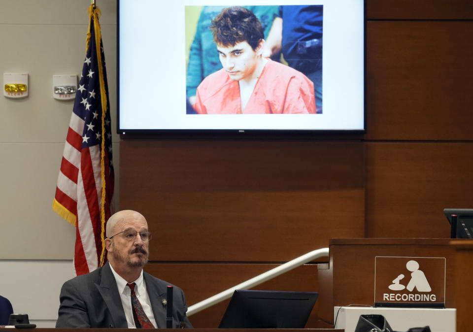 Broward Sheriff's Office Detective John Curcio testifies as a photograph of convicted Marjory Stoneman Douglas High School shooter Nikolas Cruz is displayed overhead during the trial of former MSD School Resource Officer Scot Peterson at the Broward County Courthouse in Fort Lauderdale, Fla., on Wednesday, June 21, 2023. Broward County prosecutors charged Peterson, a former Broward Sheriff's Office deputy, with criminal charges for failing to enter the 1200 Building at the school and confront the shooter. (Amy Beth Bennett/South Florida Sun-Sentinel via AP, Pool)