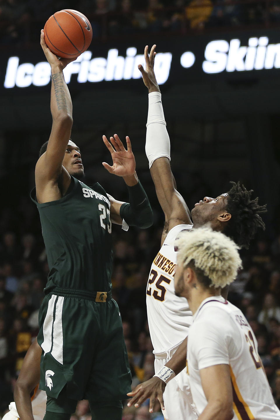 Michigan State's Xavier Tillman, left, shoots over Minnesota's Daniel Oturu (25) during an NCAA college basketball game Sunday, Jan. 26, 2020, in Minneapolis. (AP Photo/Stacy Bengs)