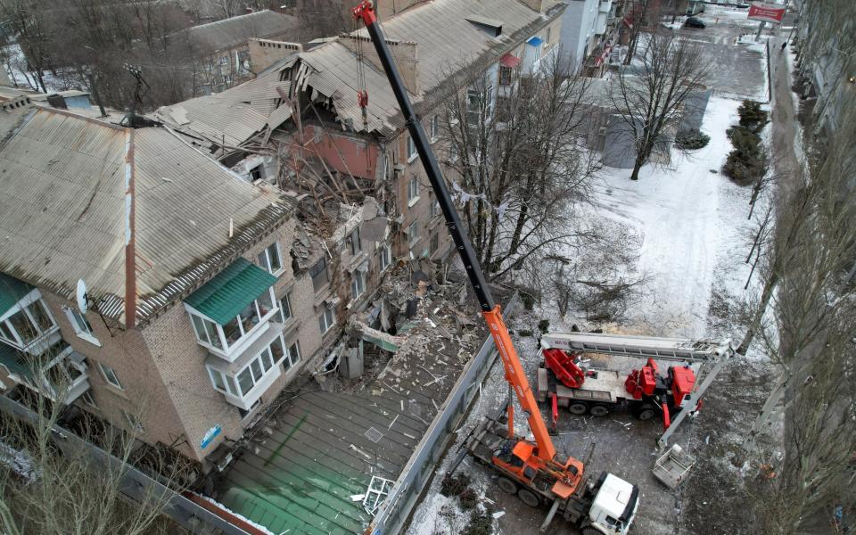 Rescuers use a crane to remove debris of a multistorey residential building damaged in recent shelling in the course of Russia-Ukraine conflict in Donetsk, Russian-controlled Ukraine, February 4, 2023. REUTERS/Pavel Klimov - REUTERS/Pavel Klimov