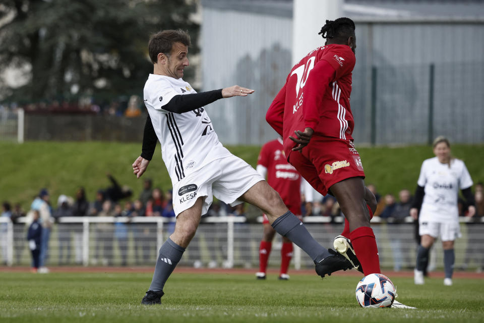 French President Emmanuel Macron,left, participates in the Varietes Club charity football match to benefit children in hospital, at the Bernard Giroux stadium in Plaisir, outside Paris, Wednesday, April 24, 2024. (Benoit Tessier/Pool via AP)