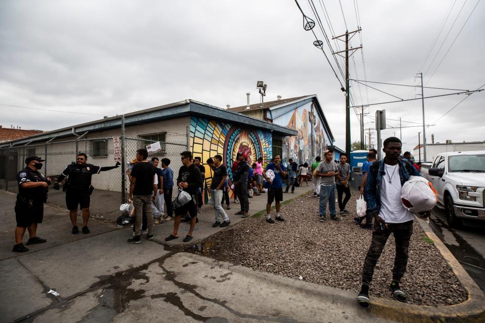 Migrants wait outside of Sacred Heart Church on the morning of Sept,. 13, 2023 as police ask the migrants to allow city services to clean up the area. The migrants have been arriving in larger numbers in the last two weeks.