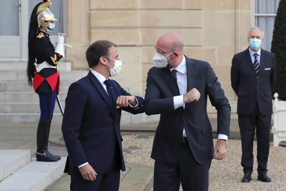 France's President Emmanuel Macron, left, greets President of the European Council Charles Michel, with an elbow bump prior to a meeting, at the Elysee Palace, in Paris, Thursday, Nov.12, 2020. (AP Photo/Thibault Camus)
