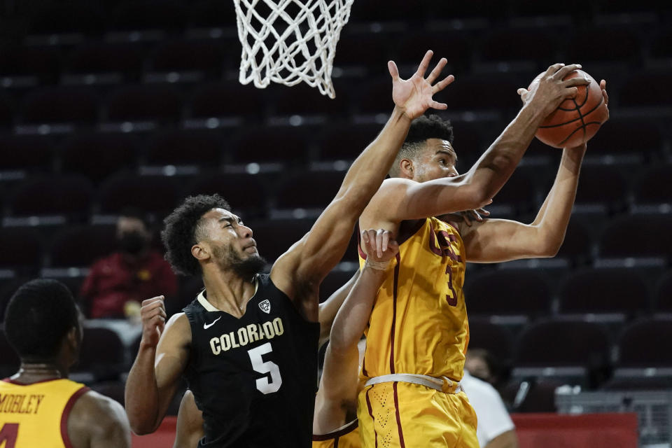 Southern California's Isaiah Mobley, right, gets a rebound next to Colorado's D'Shawn Schwartz during the first half of an NCAA college basketball game Thursday, Dec. 31, 2020, in Los Angeles. (AP Photo/Jae C. Hong)