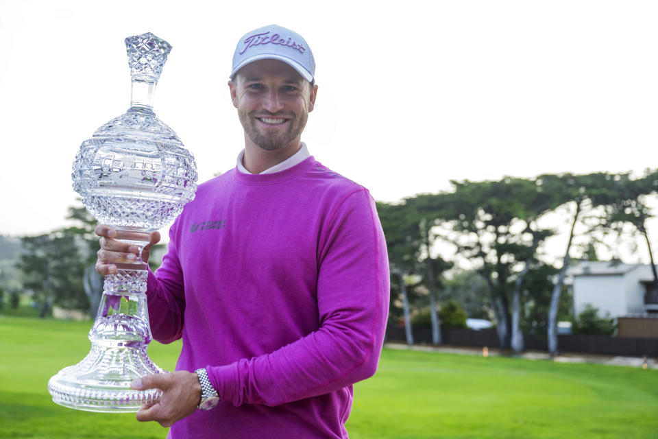 Wyndham Clark holds the trophy after winning the AT&T Pebble Beach National Pro-Am golf tournament in Pebble Beach, Calif., Monday, Feb. 5, 2024. Clark was declared the 54-hole winner at the first full signature event of the PGA Tour season when rain and dangerous wind postponed the final round on Sunday, and then tour and Monterey County officials decided it was too dangerous to play on Monday.(AP Photo/Nic Coury)