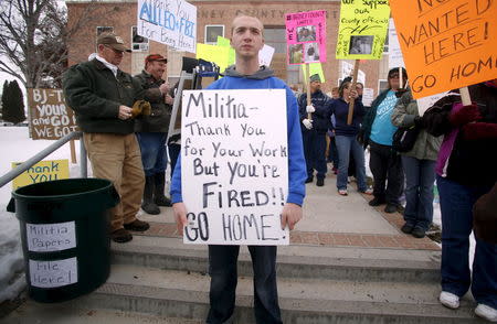 Anti-militia demonstrator Andrew Snyder carries a sign during a protest outside the Harney County Courthouse in Burns, Oregon February 1, 2016. REUTERS/Jim Urquhart