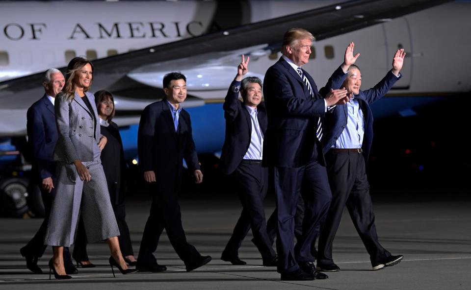 Former President Donald Trump walks with Tony Kim, fourth right, Kim Hak Song, third right, Kim Dong Chul, right, the three Americans detained in North Korea for more than a year as they arrive at Andrews Air Force Base in Md., Thursday, May 10, 2018.