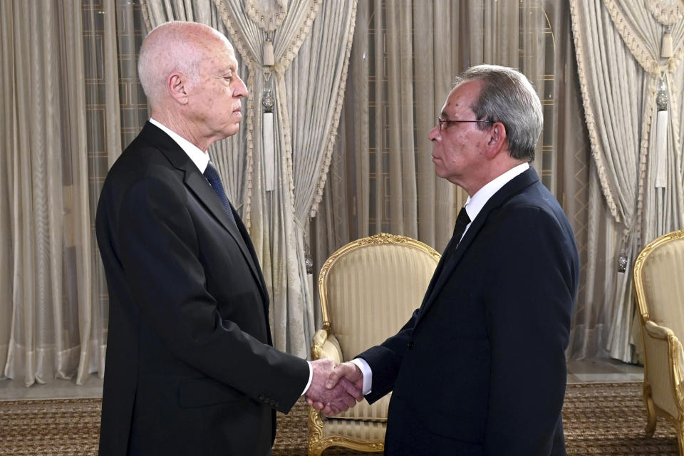 This photo provided by the Tunisian Presidential palace shows Tunisian President Kais Saied, left, shaking hands with the newly named Prime Minister Ahmed Hachani, Monday evening, Aug. 1, 2023 in Tunis. Tunisia's president has sacked the country's prime minister Najla Bouden Ramadhane, who was the first woman to hold that job in an Arab League nation. (Slim Abid/Tunisian Presidential Palace via AP)