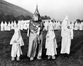 <p>Two little mascots, equipped with their own robes and hoods, flank Dr. Samuel Green, Ku Klux Klan Grand Dragon, in Atlanta, Georgia, July 23, 1948, during a massive initiation ceremony of seven hundred members of the Ku Klux Klan. (Photo: AP) </p>