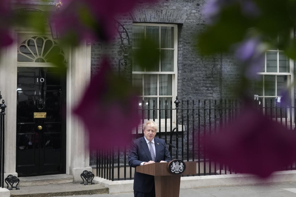 Prime Minister Boris Johnson reads a statement outside 10 Downing Street, London, formally resigning as Conservative Party leader, in London, Thursday, July 7, 2022. Johnson said Thursday he will remain as British prime minister while a leadership contest is held to choose his successor. (AP Photo/Frank Augstein)