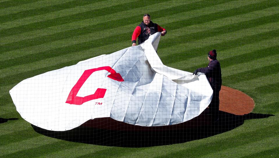 Members of the Cleveland Guardians grounds crew pulls the tarp over the mound last week at Progressive Field.