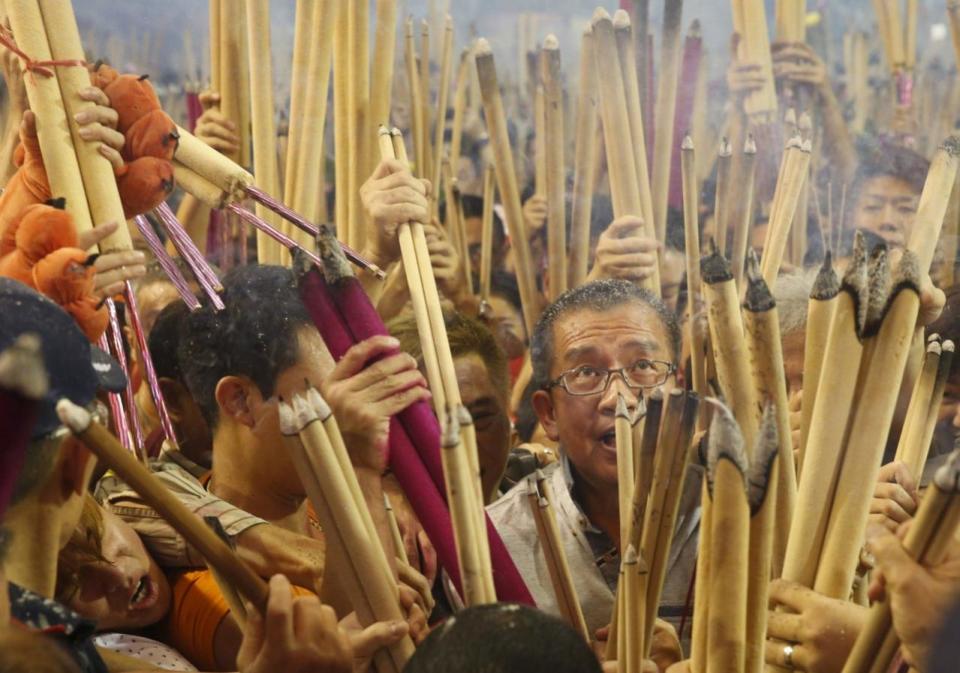 People crowd around the urn as they wait to plant the first joss stick of the Lunar New Year of the Monkey at the stroke of midnight at the Kwan Im Thong Hood Cho temple on 7 February. Photo: Reuters/Edgar Su.