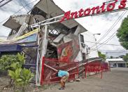 A resident inspects a building collapsed during an earthquake in Cebu city, central Philippines October 15, 2013. At least six people were killed when buildings collapsed on islands popular with tourists in the central Philippines on Tuesday, radio reports said, after an earthquake measuring 7.2 hit the region. (REUTERS)