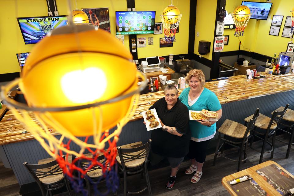 2 Gals Sports Bar and Grill owners, from left, Grace and Carol Rodrigues show off some of the food at their 201 North Quincy St., Abington, location on Friday, May 27, 2022.