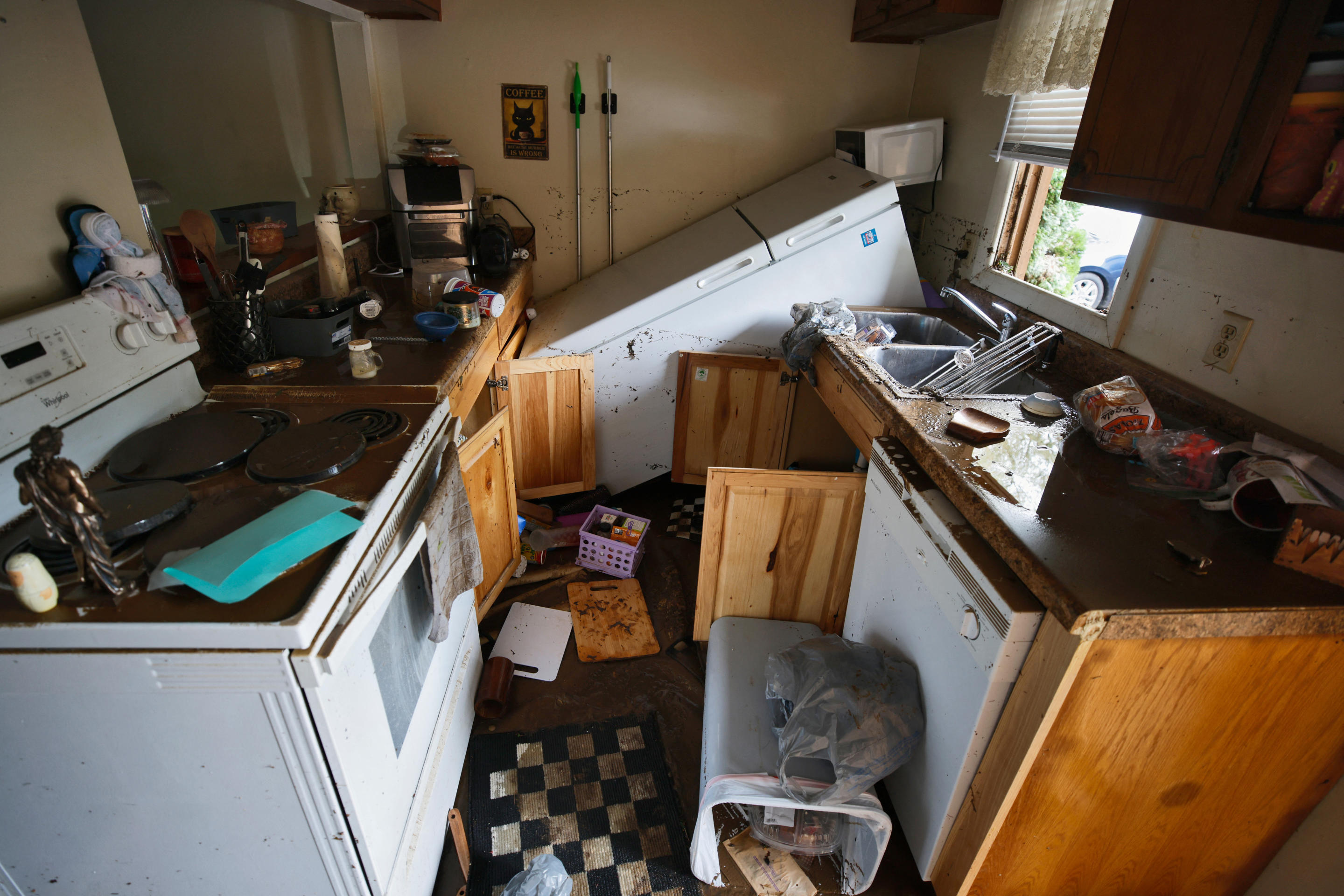 A refrigerator lies overturned in the middle of a destroyed kitchen in a flooded home in Boone, North Carolina