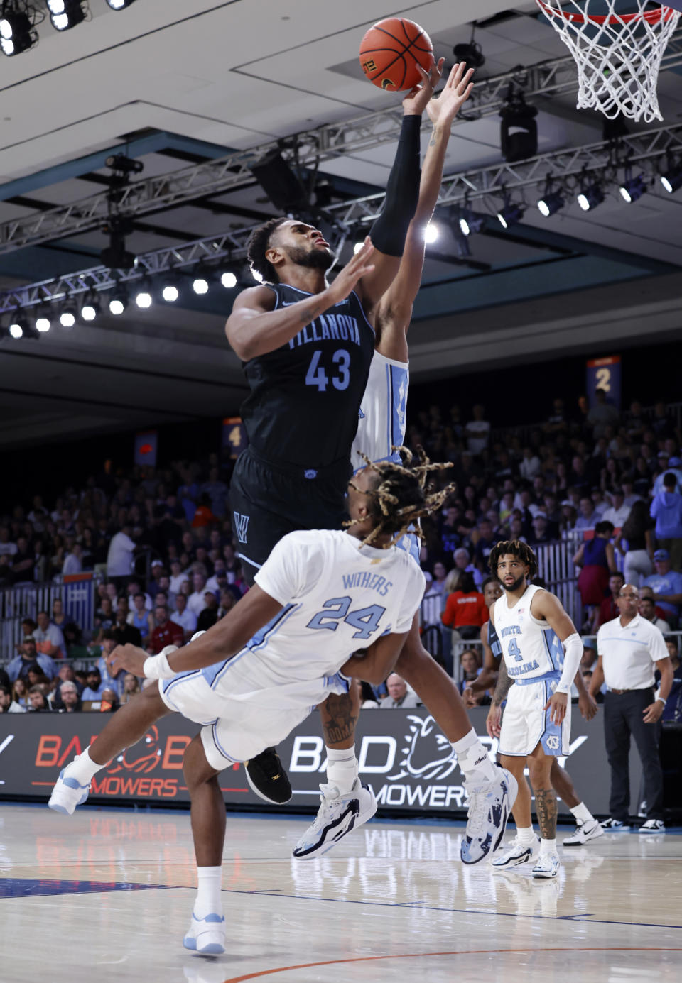 In a photo provided by Bahamas Visual Services, Villanova's Eric Dixon shoots the ball as North Carolina's Jae'Lyn Withers goes down during the first half of an an NCAA college basketball game in the Battle 4 Atlantis at Paradise Island, Bahamas, Thursday, Nov. 23, 2023. (Tim Aylen/Bahamas Visual Services via AP)