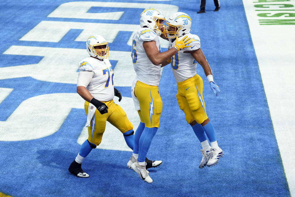 Los Angeles Chargers running back Austin Ekeler, right, celebrates his rushing touchdown with Hunter Henry (86) and Ryan Groy (72) during the first half of an NFL football game Sunday, Sept. 27, 2020, in Inglewood, Calif. (AP Photo/Ashley Landis )