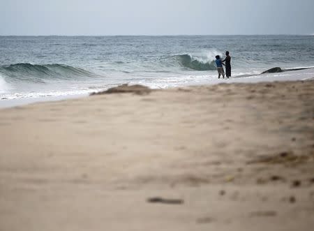 People enjoy the sea at the beach in Seenigama December 20, 2014. REUTERS/Dinuka Liyanawatte