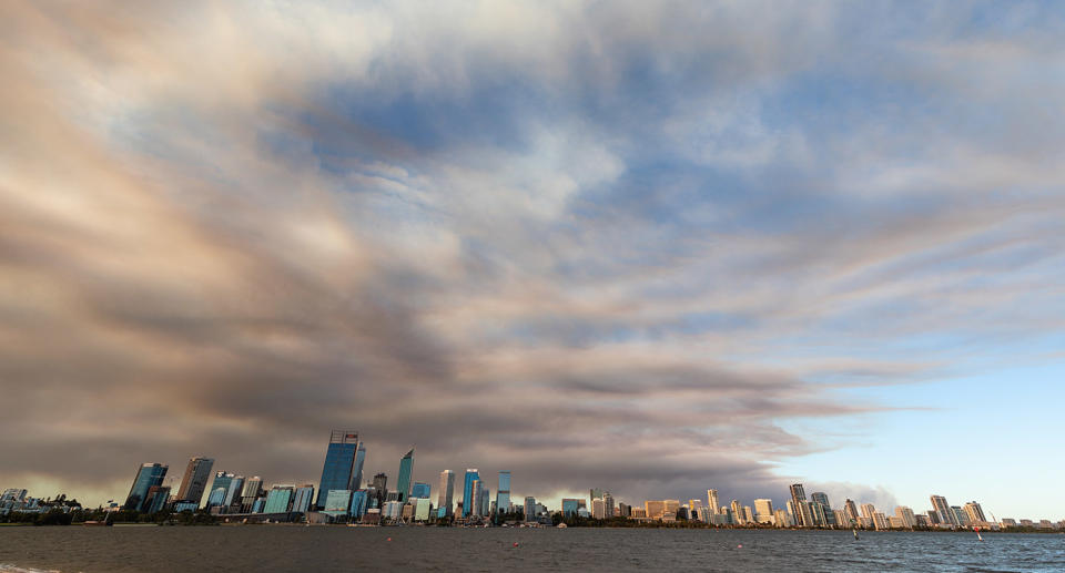 Smoke caused by a bushfire in the Perth hills suburb of Wooroloo rises behind the Perth city skyline on Monday, February 1, 2021. AAP Image/Richard Wainwright) NO ARCHIVING