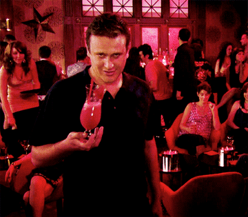 Jason Segel holding a fruity cocktail.