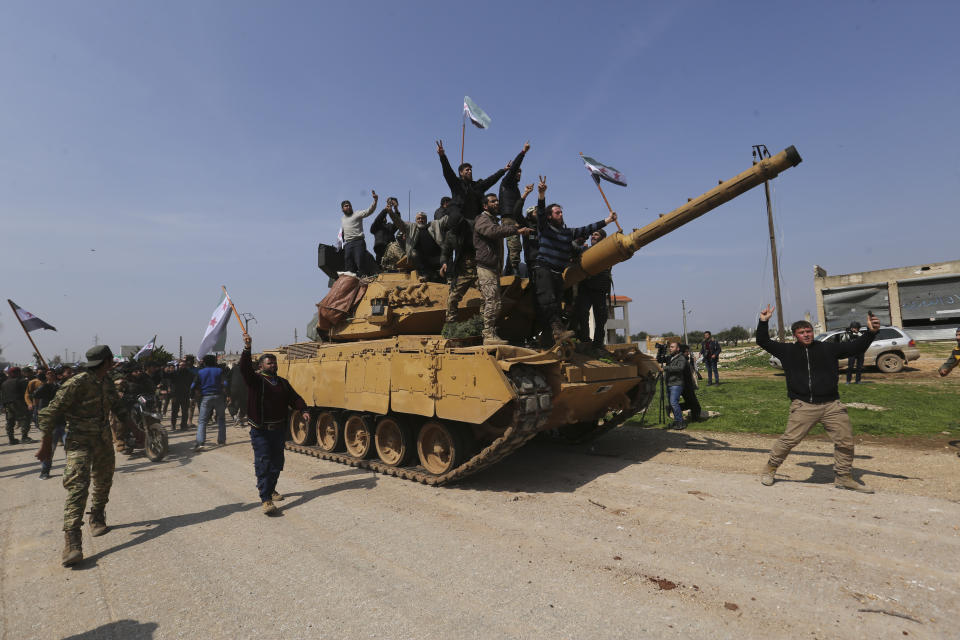 Syrians climb on a Turkish tank in Neyrab, Sunday, March 15, 2020 as they protest agreement on joint Turkish and Russian patrols in northwest Syria. Patrols on the M4 highway, which runs east-west through Idlib province, are part of a cease-fire agreed between Turkey and Russia after an escalation in fighting that saw the Turkish military in direct conflict with Syrian government troops.( (AP Photo/Ghaith Alsayed)