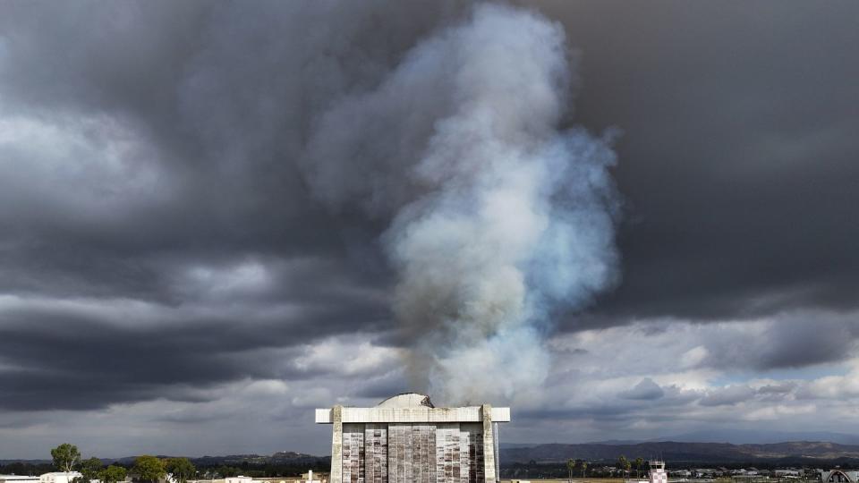 Firefighters work to control a blaze at the north blimp hangar at the former Marine Corps Air Station Tustin in Tustin, Calif., on Tuesday, Nov. 7, 2023. (Jeff Gritchen/The Orange County Register via AP)