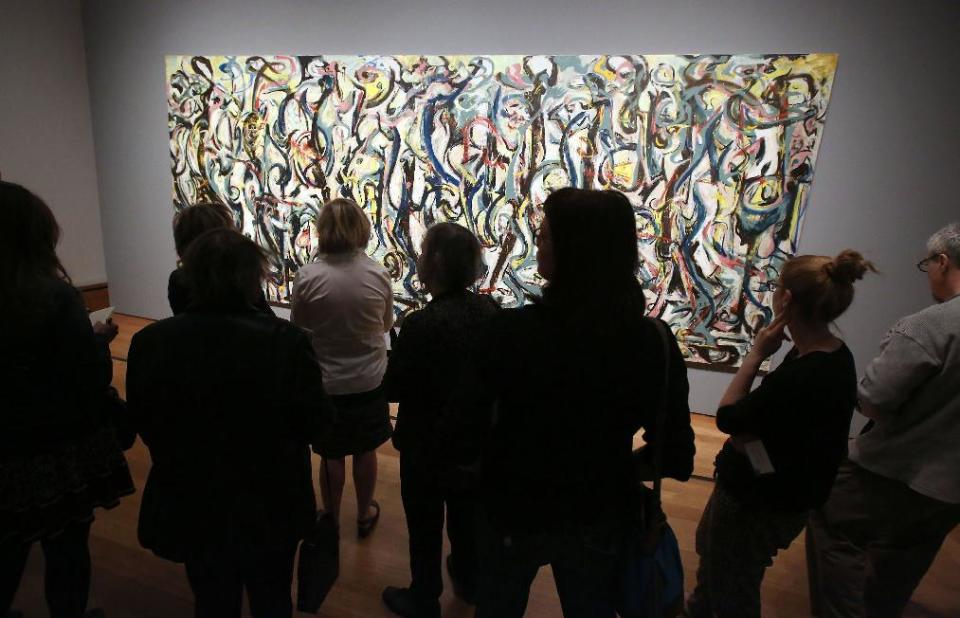 Miembros de medios de comunicación ven la pintura “Mural” de Jackson Pollock de 1943, en el Museo J. Paul Getty en Los Angeles el lunes 10 de marzo de 2014. El óleo sobre lienzo de más de 2,44 metros (8 pies) de alto por casi 6 metros (20 pies) de ancho pasó más de un año oculto en el Museo J. Paul Getty, donde atravesó una vasta restauración. La pintura, propiedad de la Universidad de Iowa, estará en el Museo J. Paul Getty del 11 de marzo al 1 de junio de 2014. (Foto AP/Nick Ut )