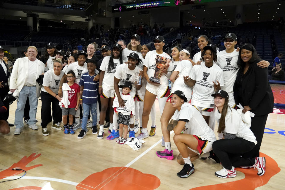 The Las Vegas Aces, with team owner Mark Davis, left, pose for a team photo after defeating the Chicago Sky in the WNBA Commissioner's Cup basketball game Tuesday, July 26, 2022, in Chicago. The Aces won 93-83. (AP Photo/Charles Rex Arbogast)