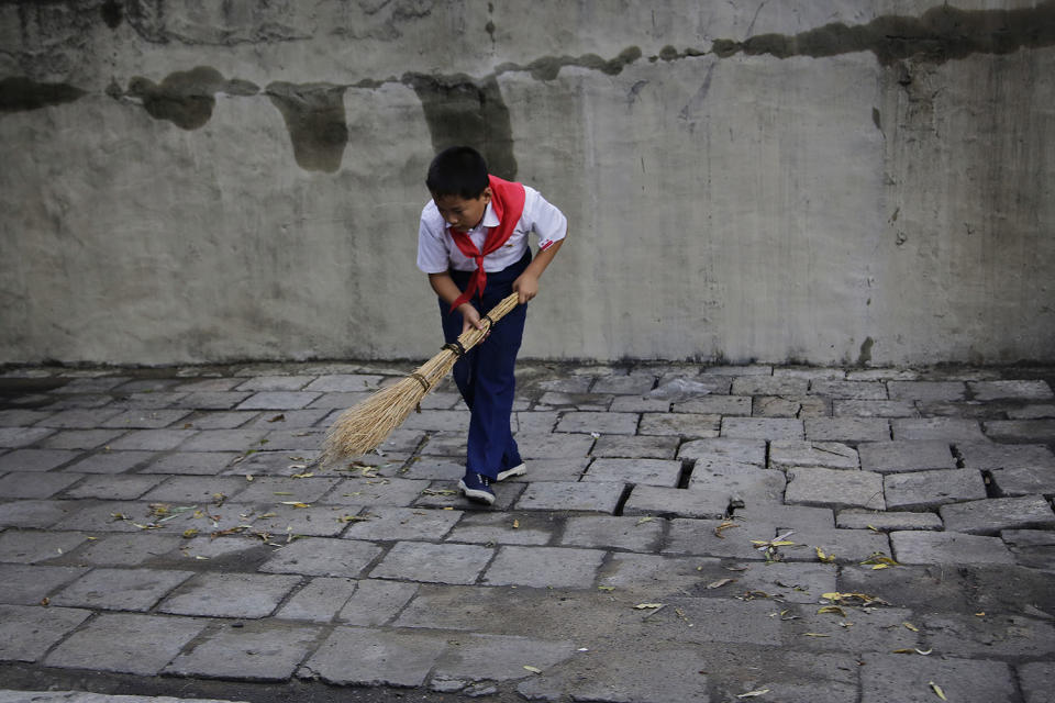 <p>A schoolboy sweeps a sidewalk on July 28, 2017, in Pyongyang, North Korea. (Photo: Wong Maye-E/AP) </p>