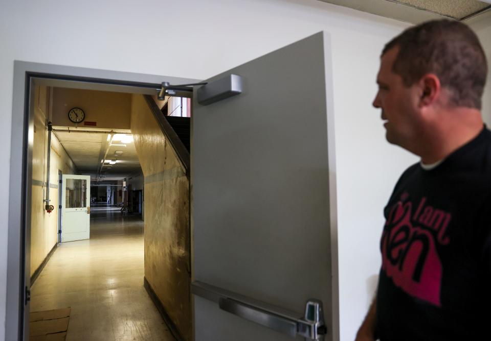 Silverton Middle School principal Brett Davisson opens a secured door to an abandoned part of the school. Parts of the building are not in use due to safety issues.