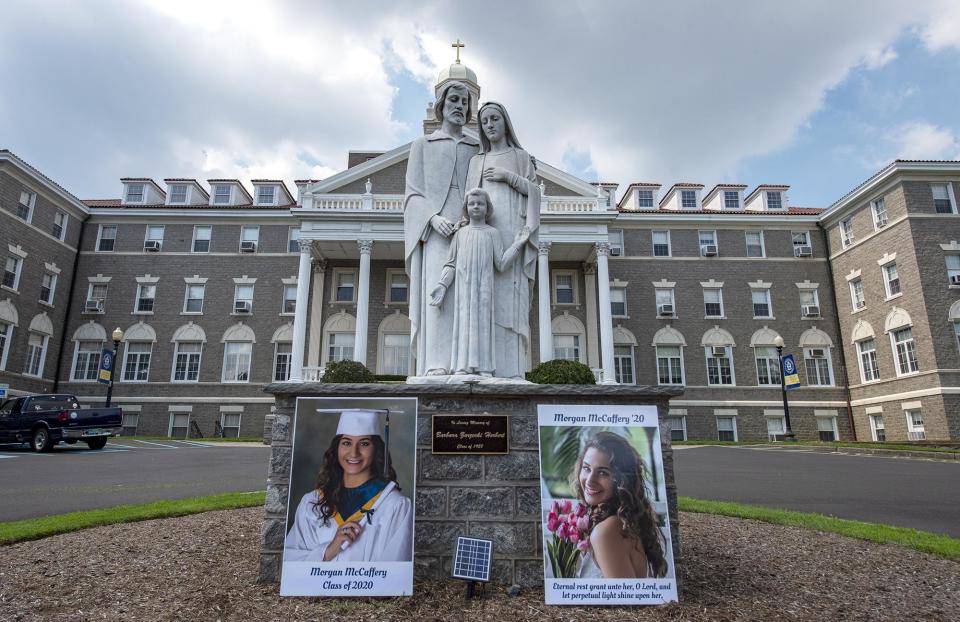 Photos of dating violence victim Morgan McCaffery, a 2020 graduate of Nazareth Academy in Philadelphia, rest next to the Holy Family statue in front of the high school.