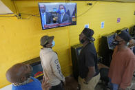 People gather inside a convenience store in the Houston neighborhood where George Floyd grew up, to listen to the verdict in the murder trial against former Minneapolis police Officer Derek Chauvin, Tuesday, April 20, 2021, in Houston. (AP Photo/David J. Phillip)